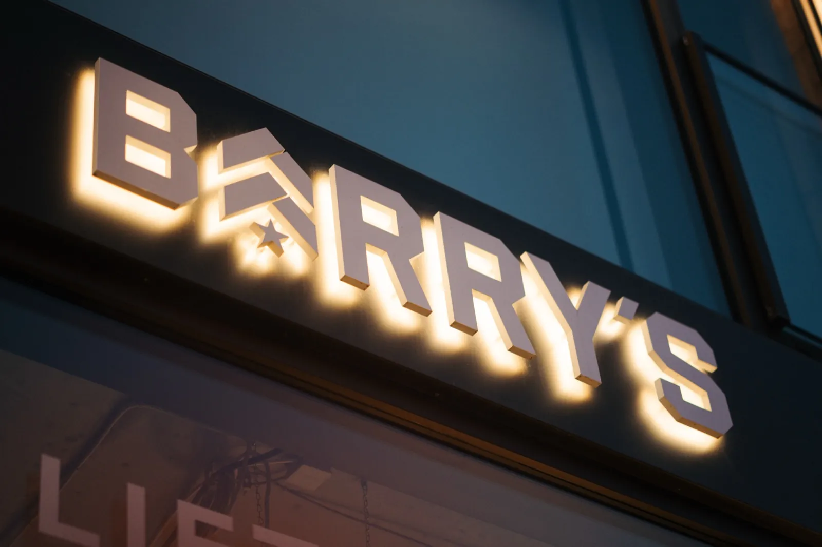 Barry's Frankfurt – Ein beleuchteter Schriftzug mit dem Logo von Barry's an einer Außenfassade