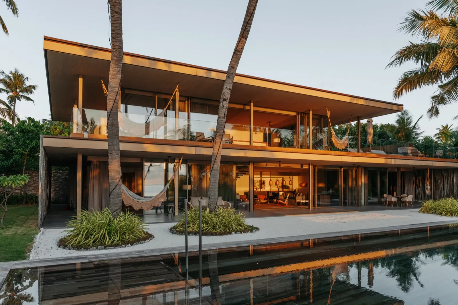 Patina Maldives – Eine moderne Luxusvilla mit Pool im warmen Abendlicht